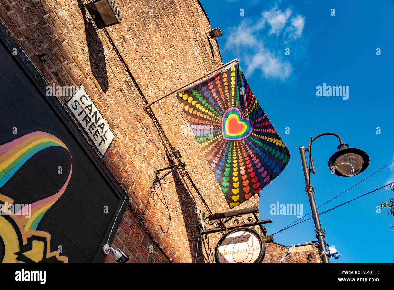 gay rainbow flag flying in Canal street in Manchester UK Stock Photo