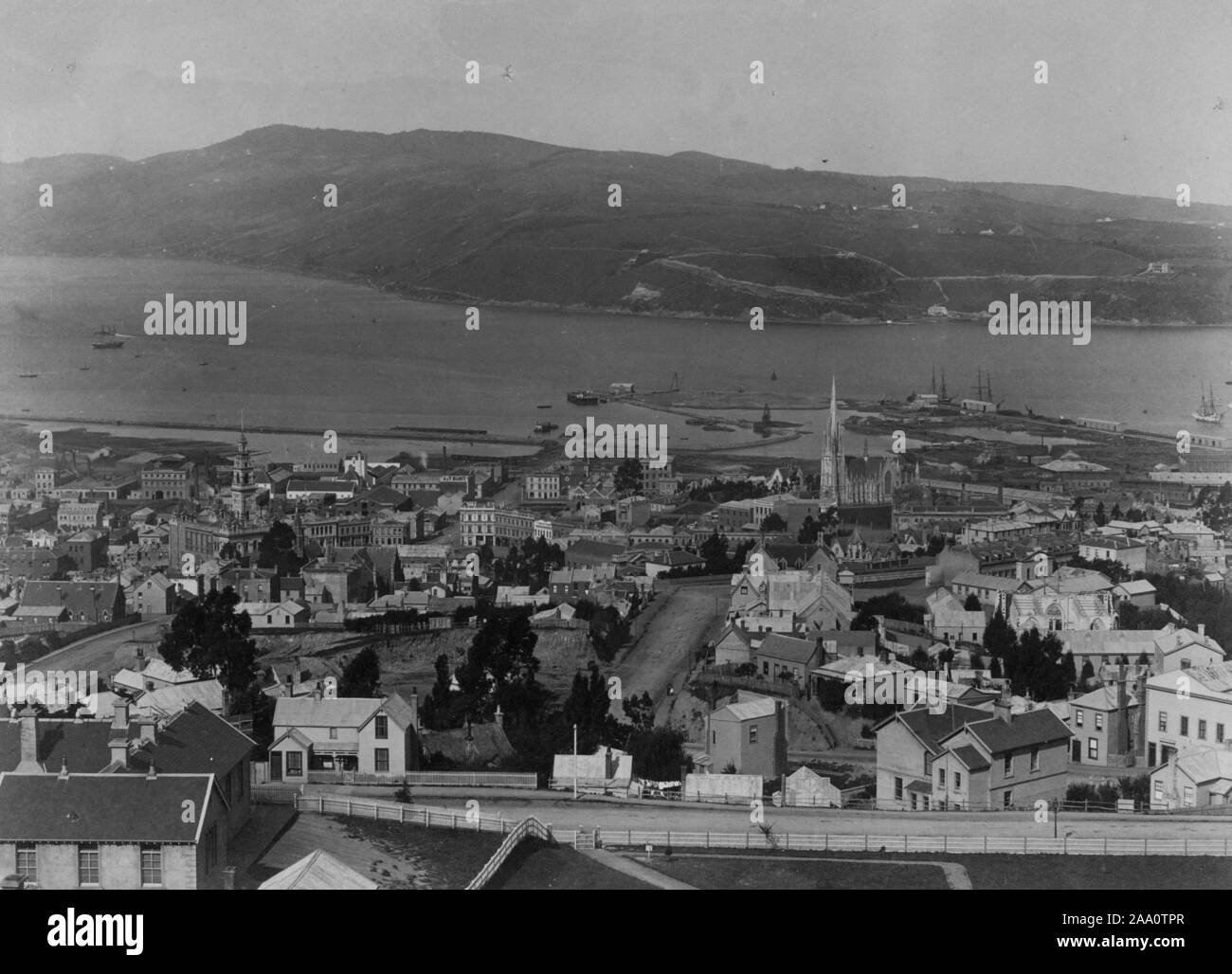 Black and white cityscape photograph of the city of Dunedin with Otago Harbour and a mountain range in the background, in the South Island, New Zealand, by photographer Frank Coxhead, 1885. From the New York Public Library. () Stock Photo