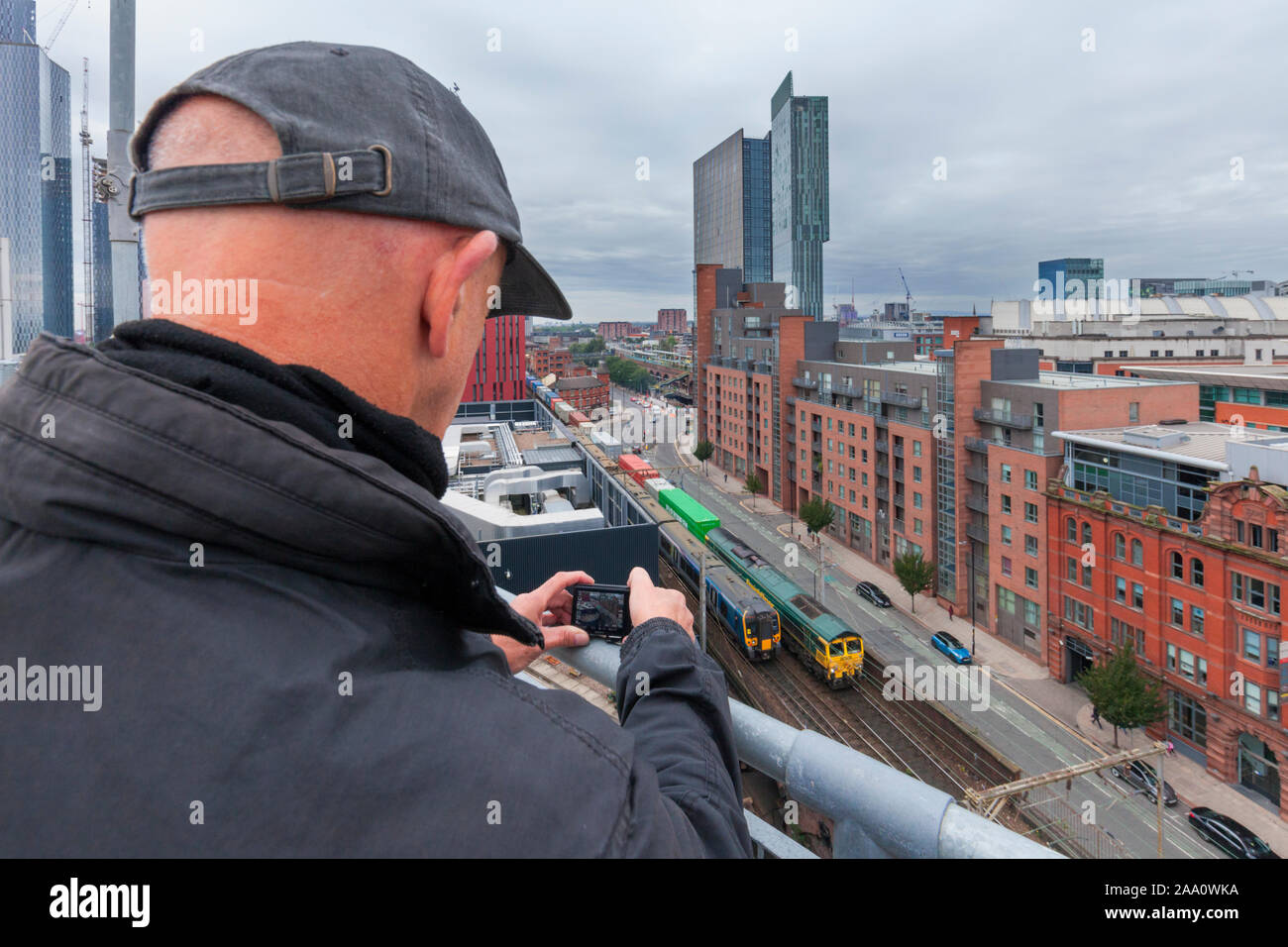 Rail enthusiast / train-spotter photographing trains at Manchester Oxford Road in the congested Castlefield viaduct in central Manchester Stock Photo