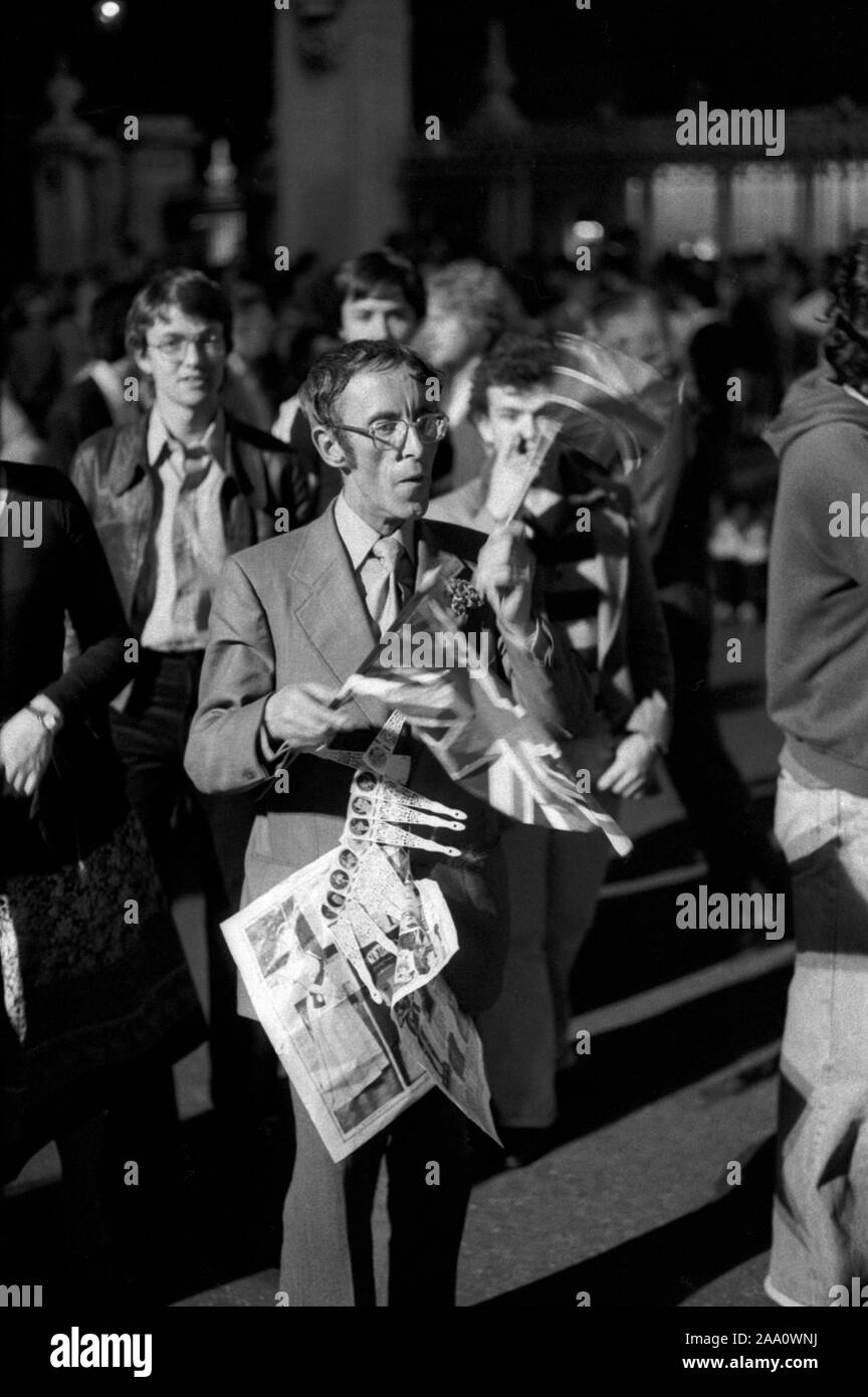 Queen Elizabeth Silver Jubilee, crowds gather at Buckingham Palace to cheer and watch the firework display 1978 to mark the end of a year of celebrations. London UK 1970s. Man selling flags. HOMER SYKES Stock Photo