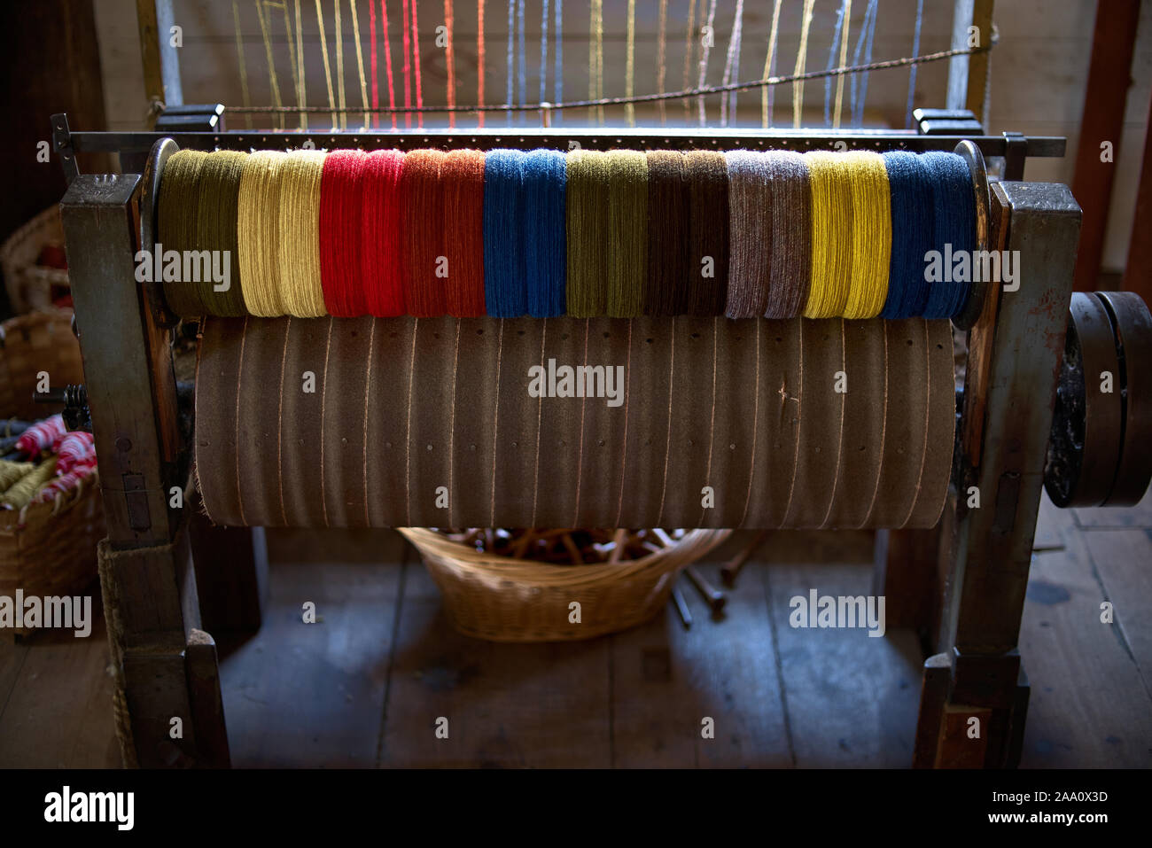 Spools of colored thread that were used in a woolen mill 1800's and early 1900's. colored woolen threads on an old loom, Traditional Yarn in Canada. Stock Photo