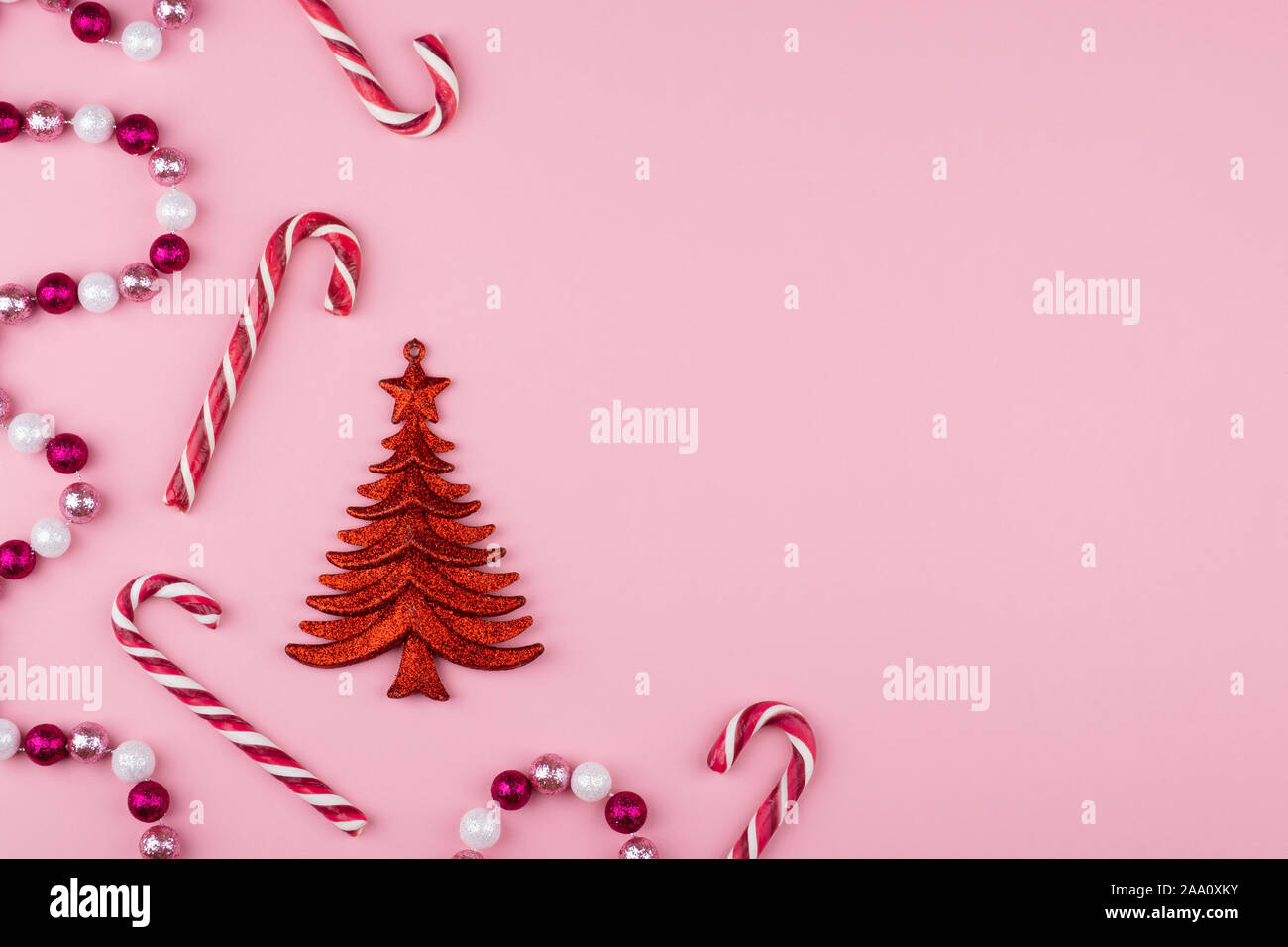 Christmas background with candy, garlands, christmas tree on a pink background. Flat lay, top view Stock Photo