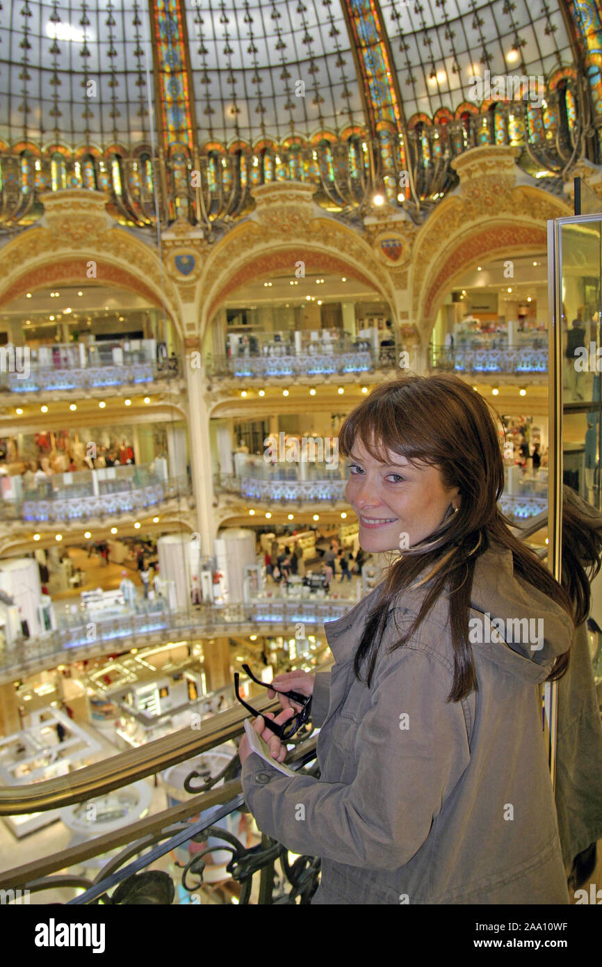 Junge Frau blickt von oben in das Kaufhaus Lafayette, Paris, Frankreich / Joung woman is lokking  into the big store Lafayette, Paris, France Stock Photo