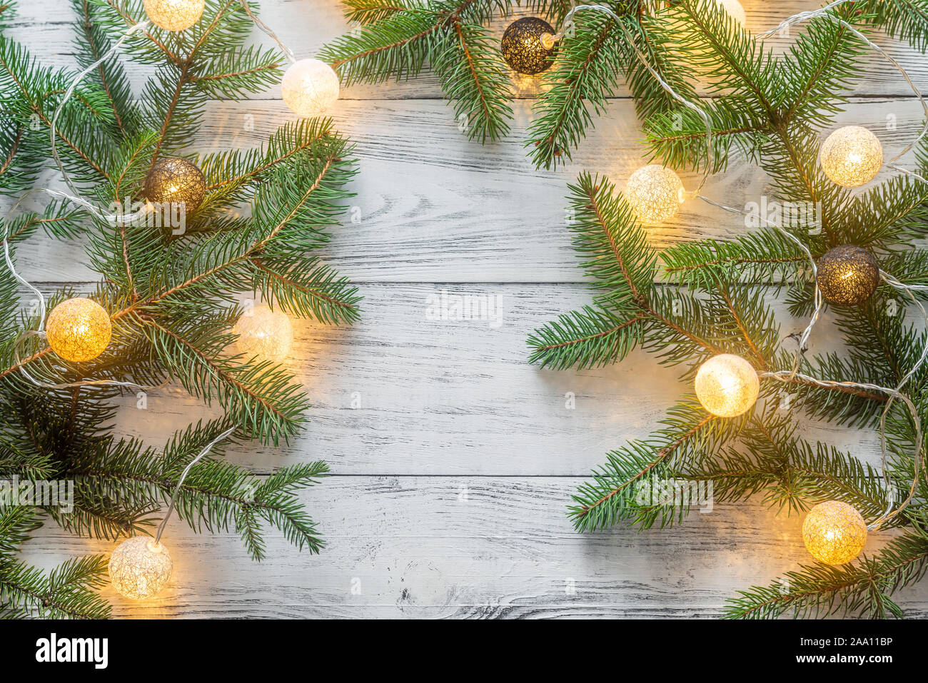 Christmas tree branches with lights on the wooden background Stock ...