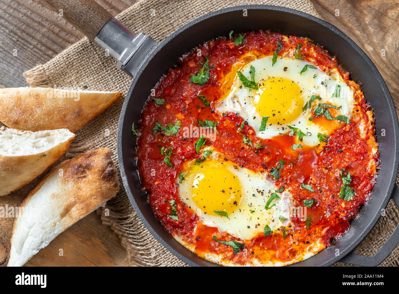 Shakshouka eggs poached in tomato sauce, served in a frying pan Stock