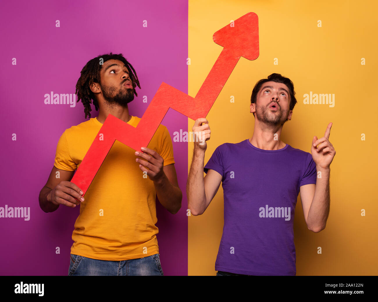 Amazed friends with funny face expression and red arrow statistic. Concept of growth, success, earn. Stock Photo