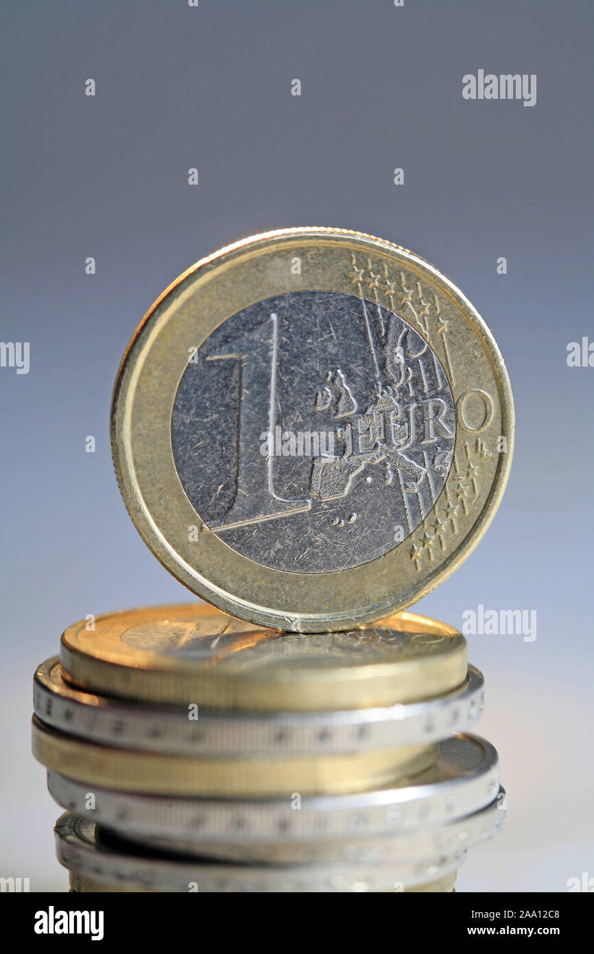Ein Euro Stück steht auf einem Stapel Euro Münzen / One Euro coin is  standing up to a pile of Euro coins Stock Photo - Alamy