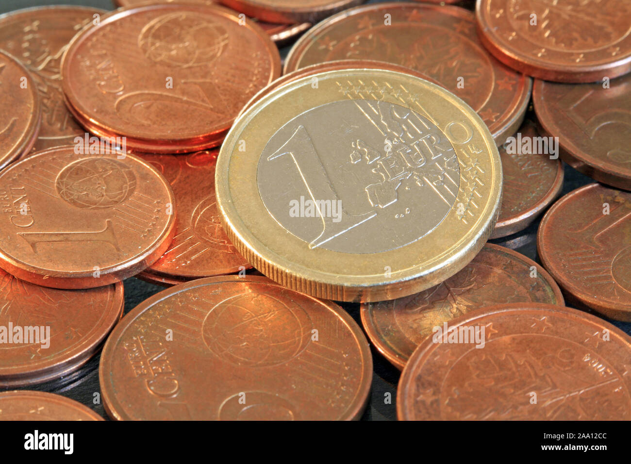Euro Münzen. Ein Euro liegt auf einem Haufen Kleingeld / Euro coins. One Euro coin is lieing up to a cluster of small coins Stock Photo