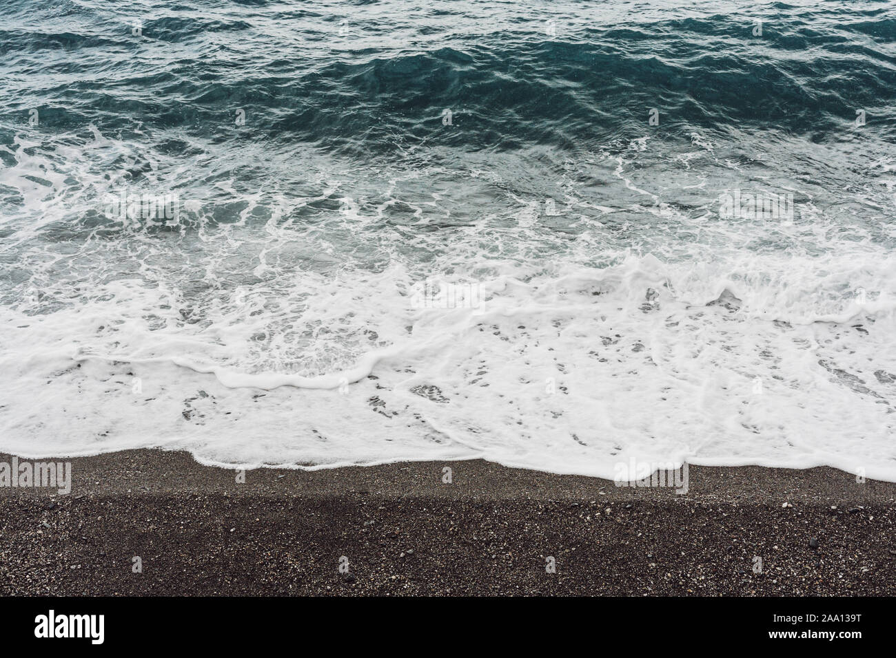 sea waves with white foam on sandy beach in coastline Stock Photo - Alamy
