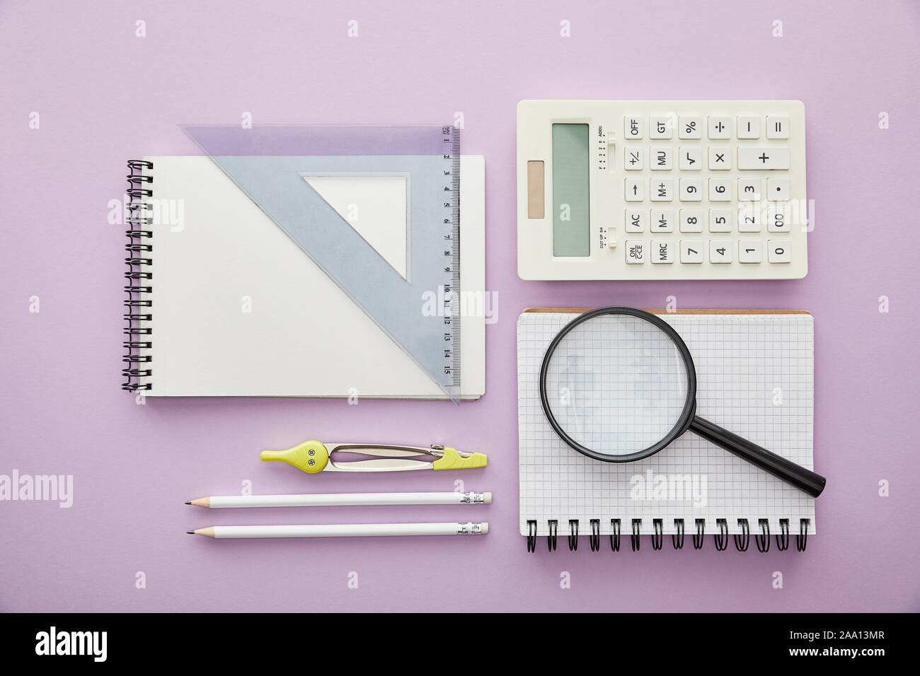 top view of magnifier and ruler triangle on notebooks near calculator ...