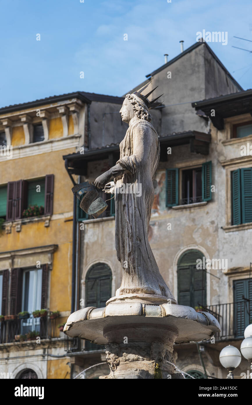 Verona, Italy - August 6, 2019: People walk by an old medieval Fontana Madonna Verona on the street Stock Photo