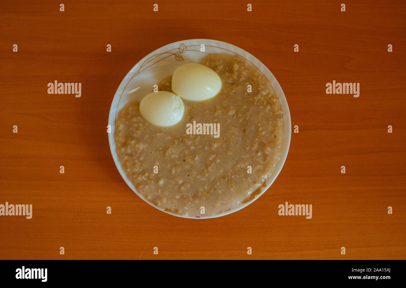 Oatmeal porridge with boiled eggs, Breakfast on the table Stock Photo