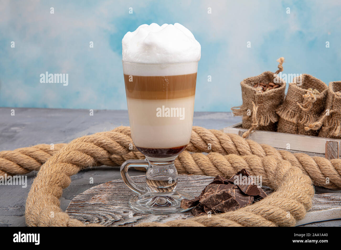 pour the frappe from the shaker into a tall glass , beautiful and clean  composition with coffee beans and amaretti biscuits Stock Photo - Alamy