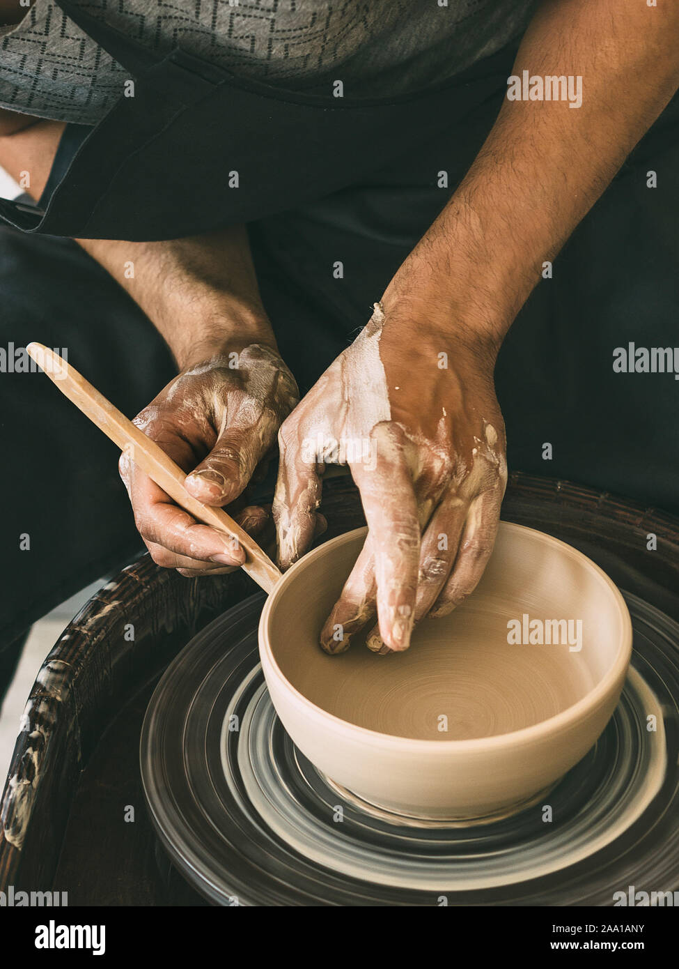 Man potterist making bowl on a potters wheel from clay in a