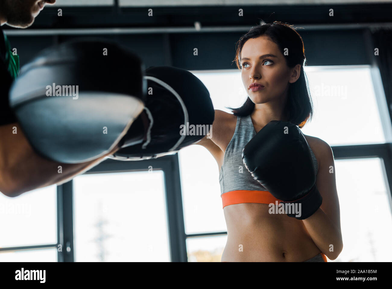 sportswoman in boxing gloves working out with sportsman in sports ...