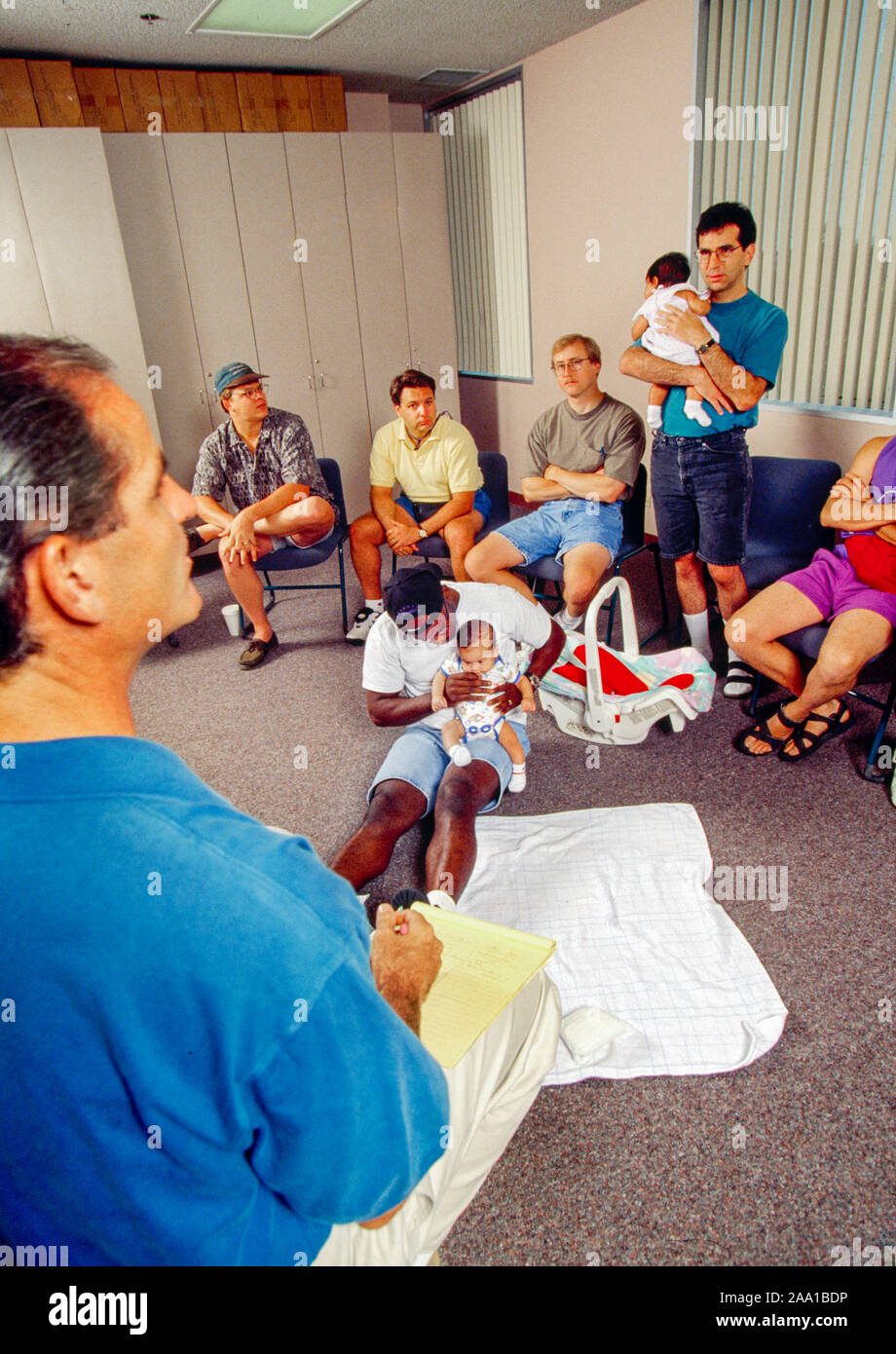 Under the eye of a leader, fathers of newborn children meet with prospective fathers at a supportive "Bootee Camp" in Mission Viejo, CA, with the purpose of allaying their fears of approaching fatherhood. MODEL RELEASE Stock Photo