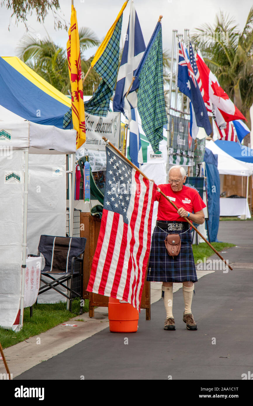 Surrounded by clan flags, a member of the Donnachaidh clan adds the stars and stripes to his display at a Scottish pride festival in Costa Mesa, CA. Stock Photo