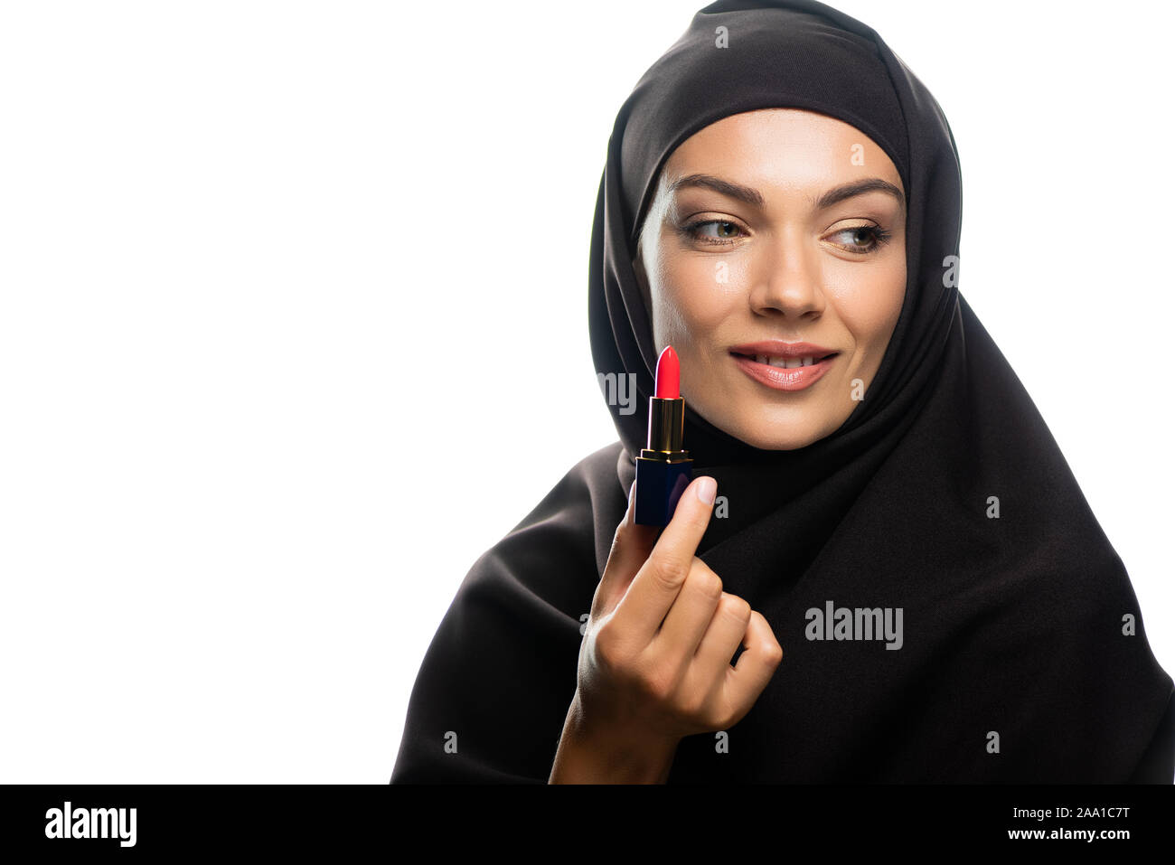 smiling young Muslim woman in hijab holding red lipstick isolated on ...