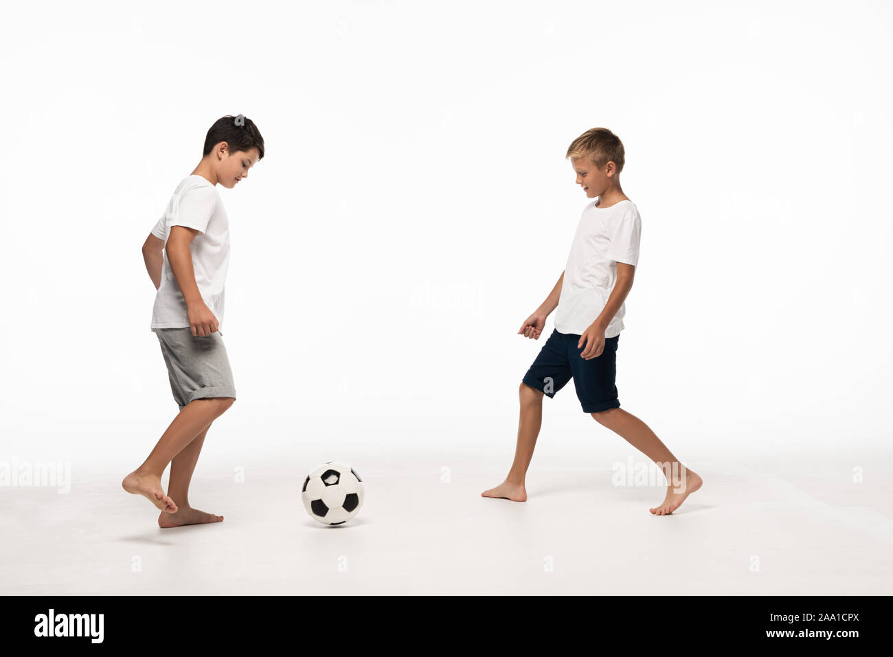 two brothers in pajamas playing football on white background Stock Photo