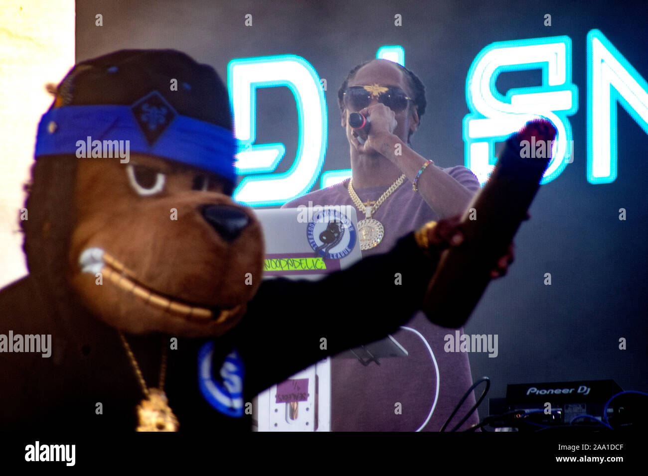 Rap singer Snoop Dogg performs with a cigar-waving costumed dog companion at an outdoor concert in Huntington Beach, CA.. Stock Photo