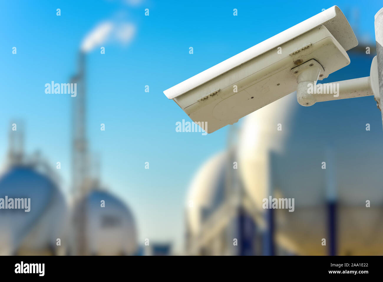 CCTV camera concept with refinery on blurry background Stock Photo