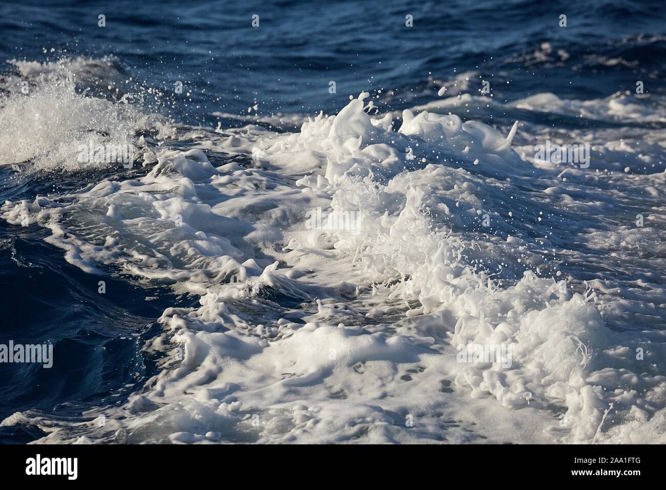 Waves with foam splasing in sea water Stock Photo - Alamy