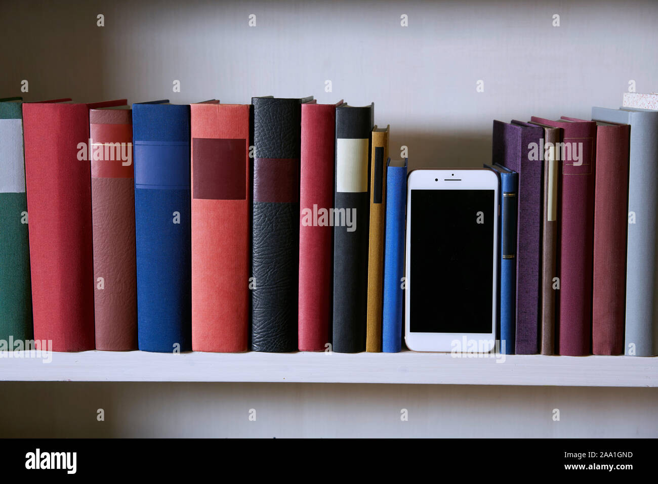 Accurate bookcase with front view of a mobile phone Stock Photo