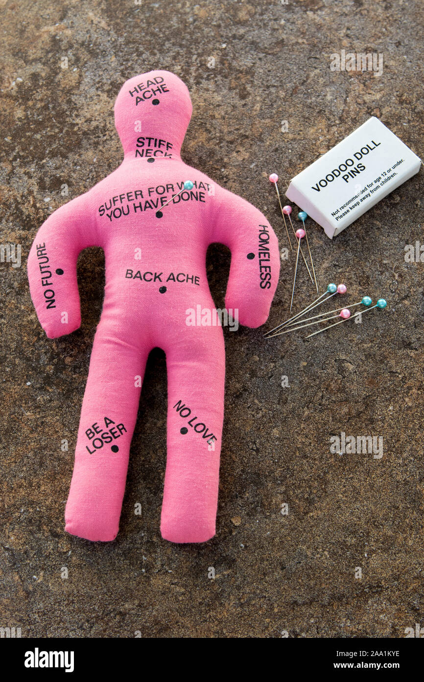 Pink Voodoo doll with a books of voodoo pins or needles Stock Photo Alamy