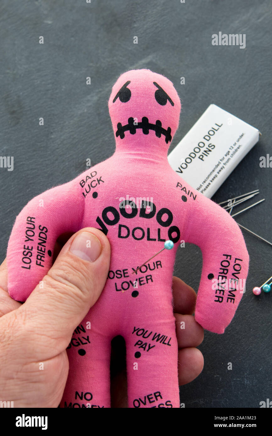 Pink Voodoo doll with a books of voodoo pins or needles Stock Photo - Alamy