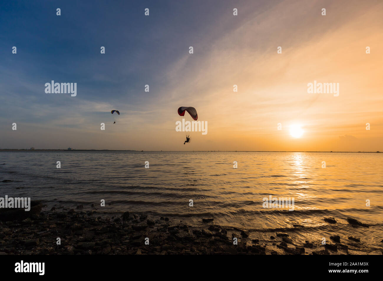 Silhouette of Paramotors flying to sky on sunset Adventure man active