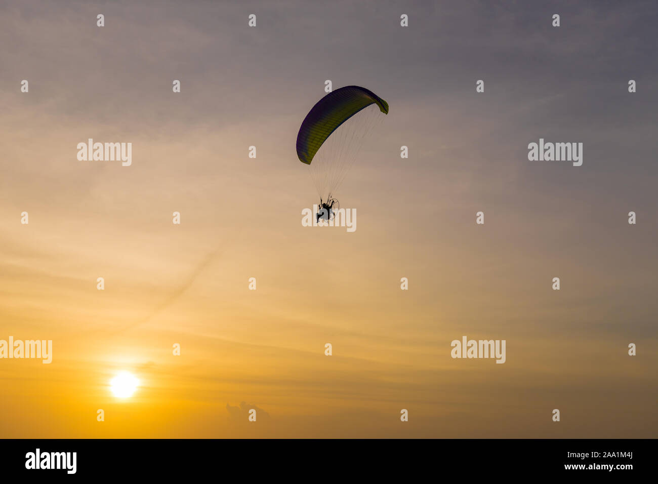 Silhouette of Paramotors flying to sky on sunset Adventure man active