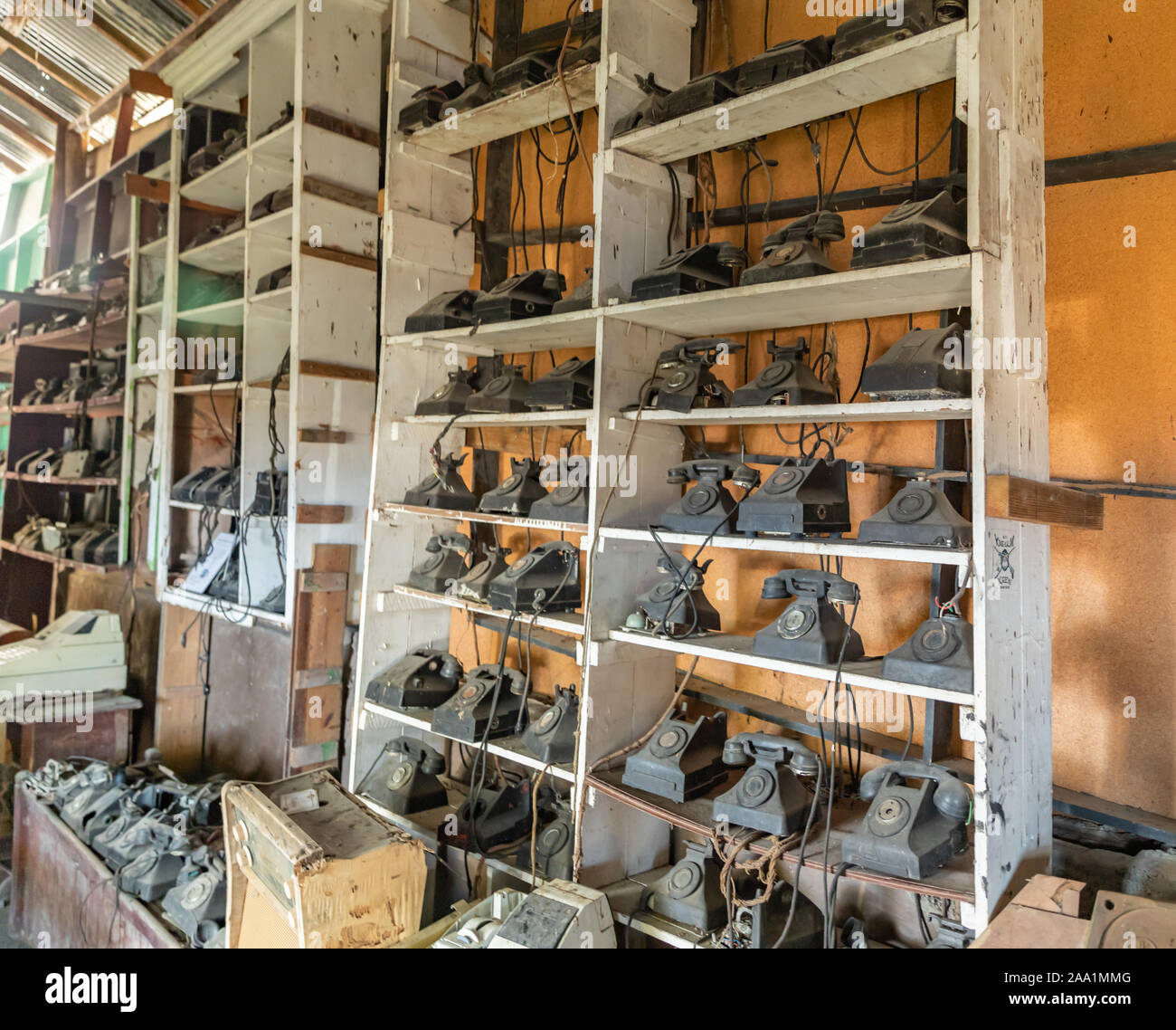 Dusty vintage telephones on shelves at Wallilabou bay storage building