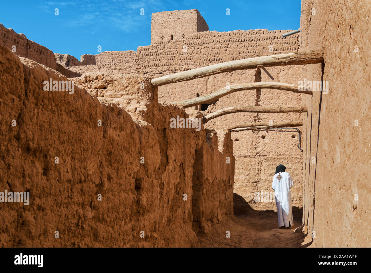 Traditional dressed man walks inside a kasbah in M'hamid, Morocco. Stock Photo