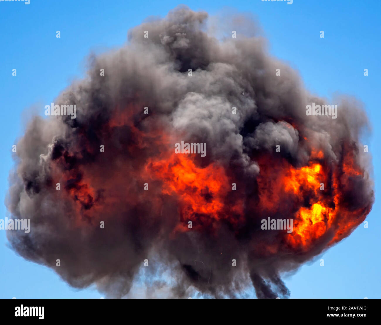 Ball of smoke and fire from mutions explosion against blue sky Stock Photo