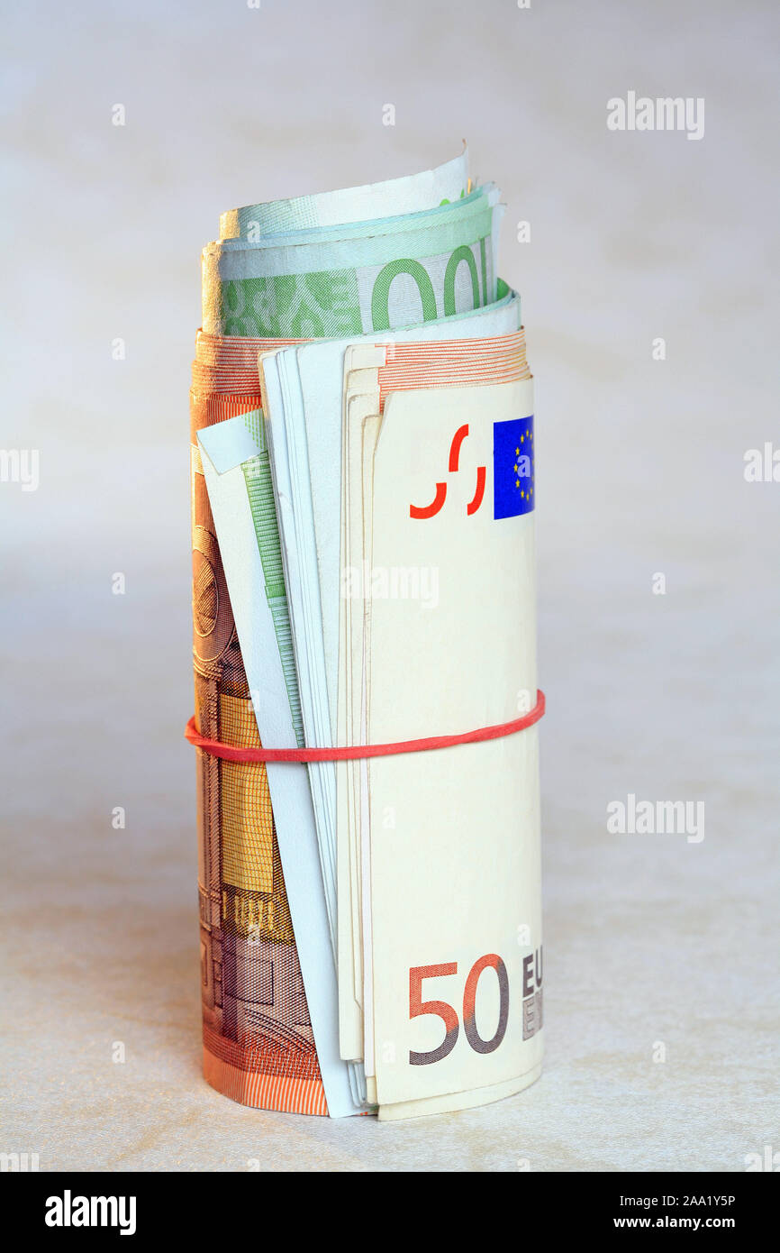 Zusammengerollte Euro Geldscheine mit einem Gummiring / Rolled Euro bank notes with a rubber ring Stock Photo