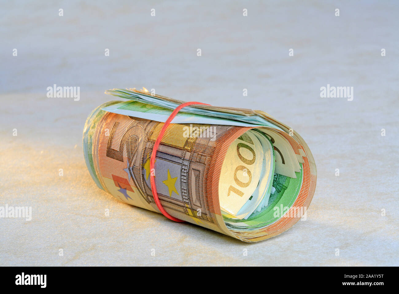 Zusammengerollte Euro Geldscheine mit einem Gummiring / Rolled Euro bank notes with a rubber ring Stock Photo