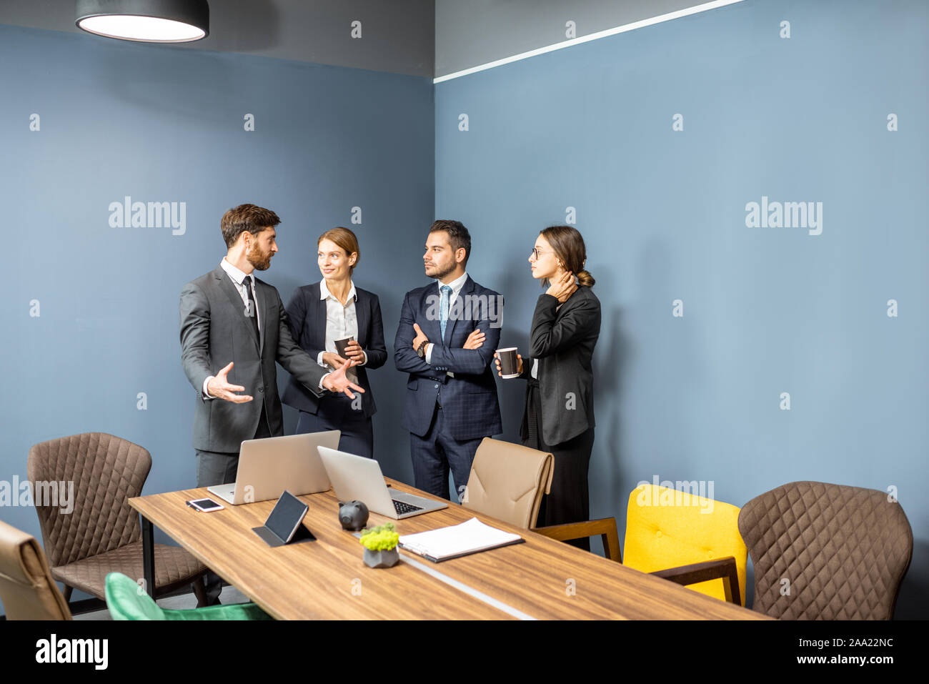 Business people having informal discussion during a coffee break in the meeting room Stock Photo
