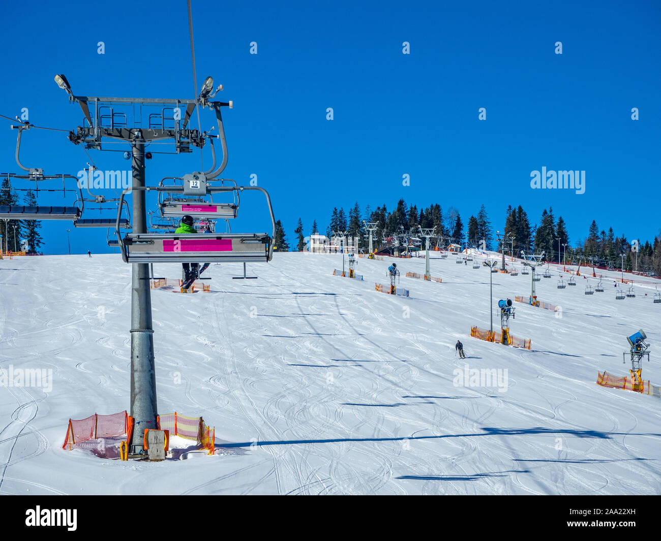 Ski slope with ski lifts (chairlifts and ski tow) and sow cannons in Bialka Tatrzanska  ski resort in Poland Stock Photo