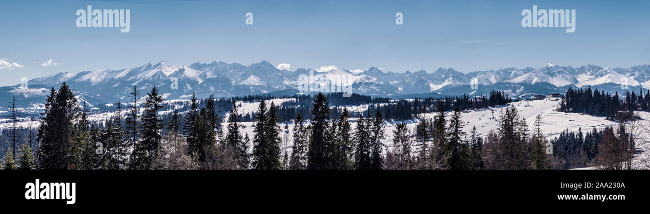 Wide panorama of Tatra mountains in winter,  viewed from Bania mountain in Bialka ski resort with ski chair lift. Far view of Kasprowy Wierch, Stock Photo