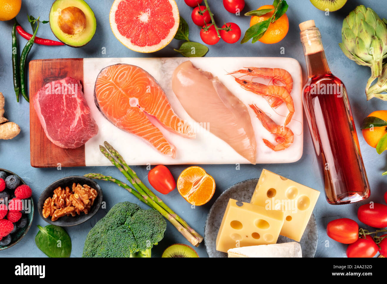 Varied diet. Different proteins, wine, fruit, vegetables, cheese, nuts. Fresh food, shot from the top. A flat lay composition. Meat, fish, poultry... Stock Photo