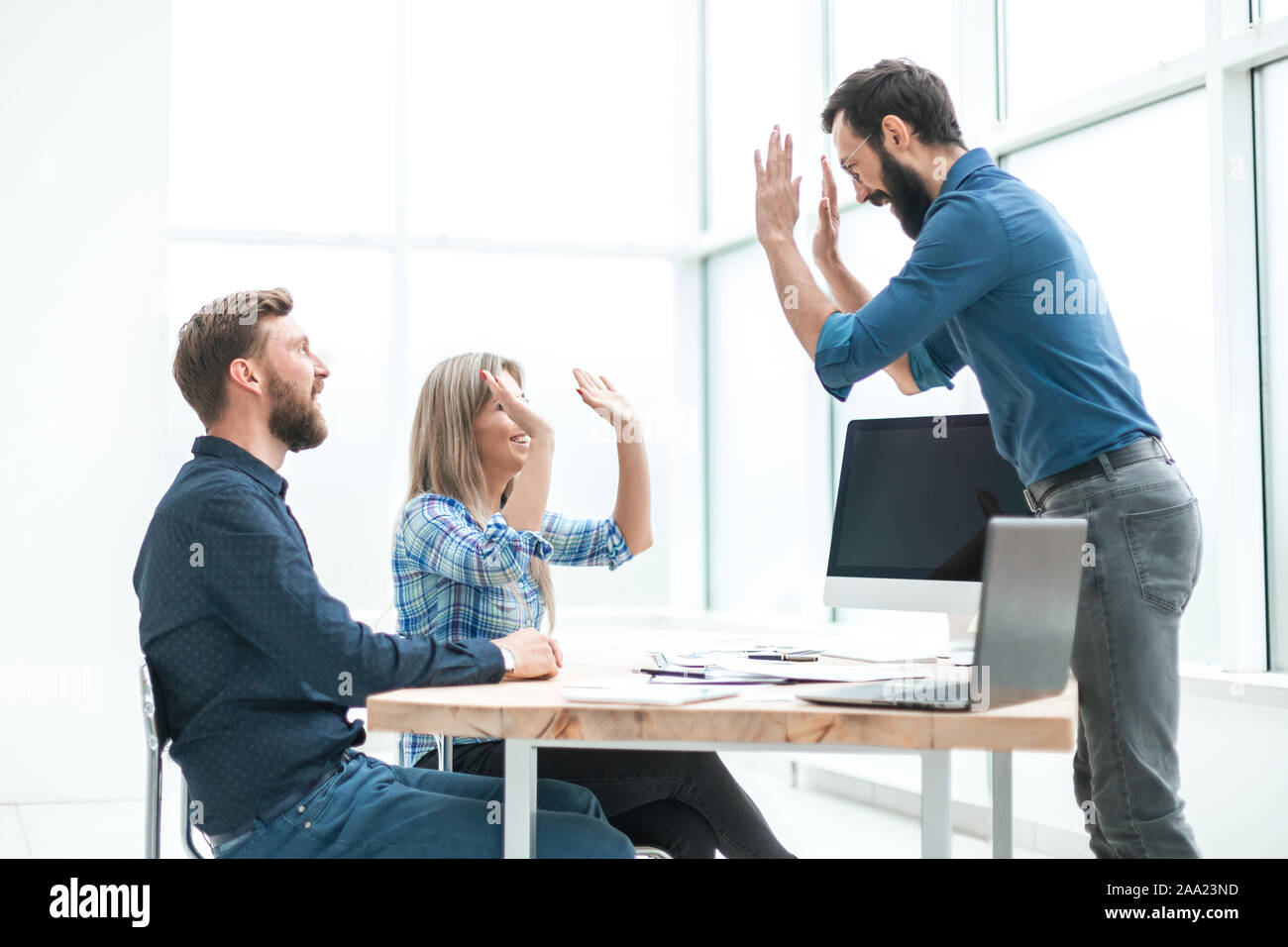 friends co-workers giving each other a high five Stock Photo