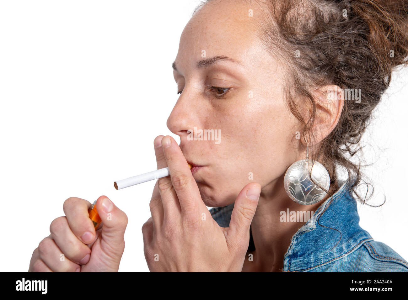 Beautiful young woman lighting cigarette hires stock photography and