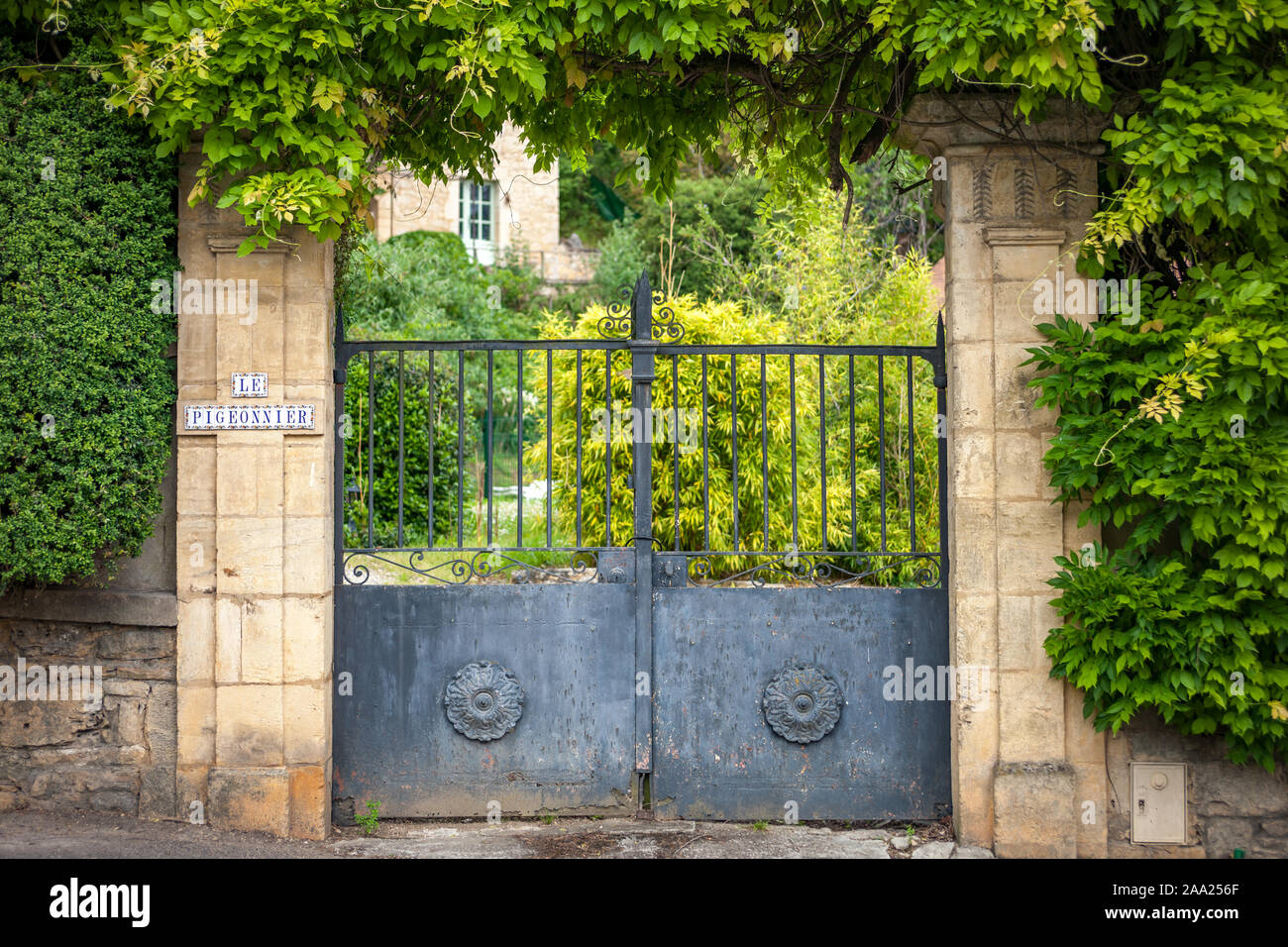Detail of old metal gate with stone walls Stock Photo