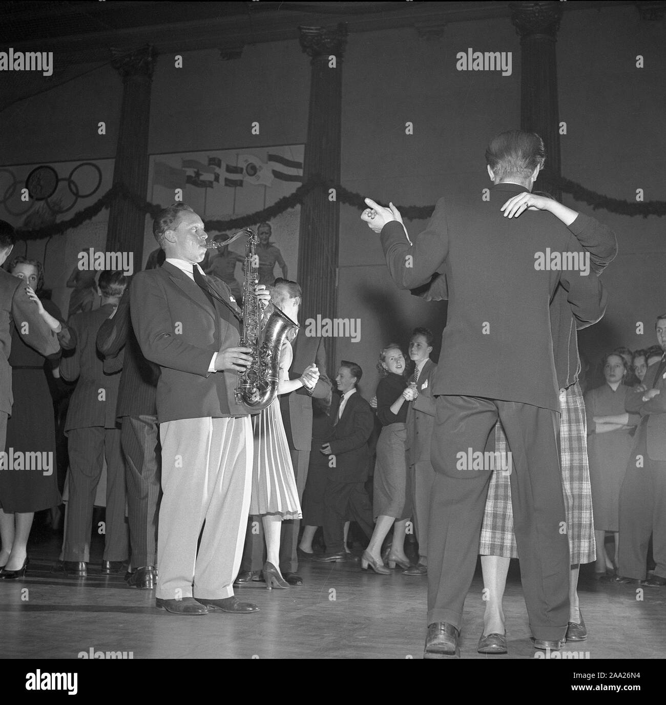 Dancing in the 1950s. The dance floor is filled with dancing couples moving to the music. A saxophonist is standing amongst them playing.  Sweden 1951. Ref 1871 Stock Photo