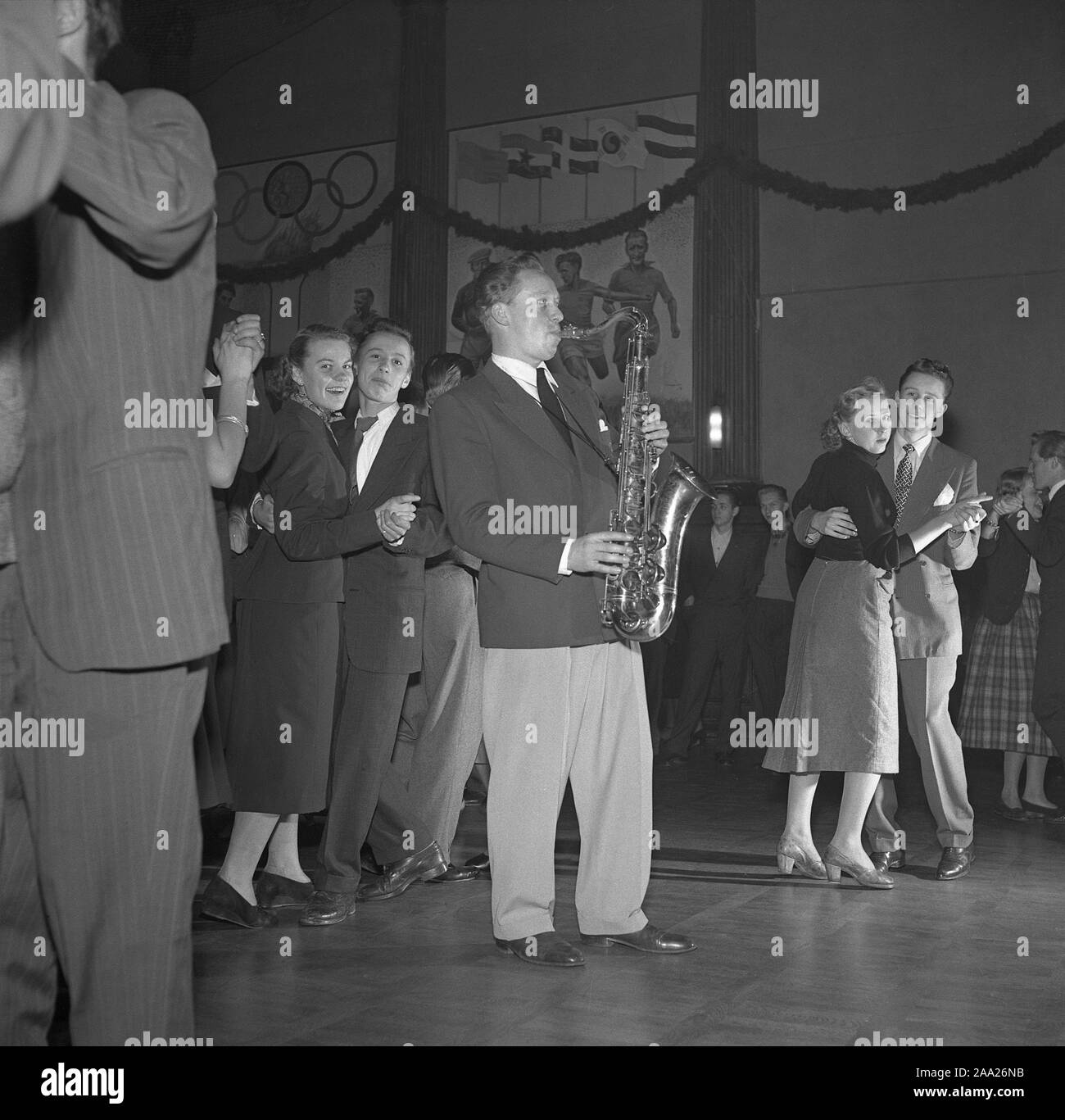 Dancing in the 1950s. The dance floor is filled with dancing couples moving to the music. A saxophonist is standing amongst them playing.  Sweden 1951. Ref 1871 Stock Photo