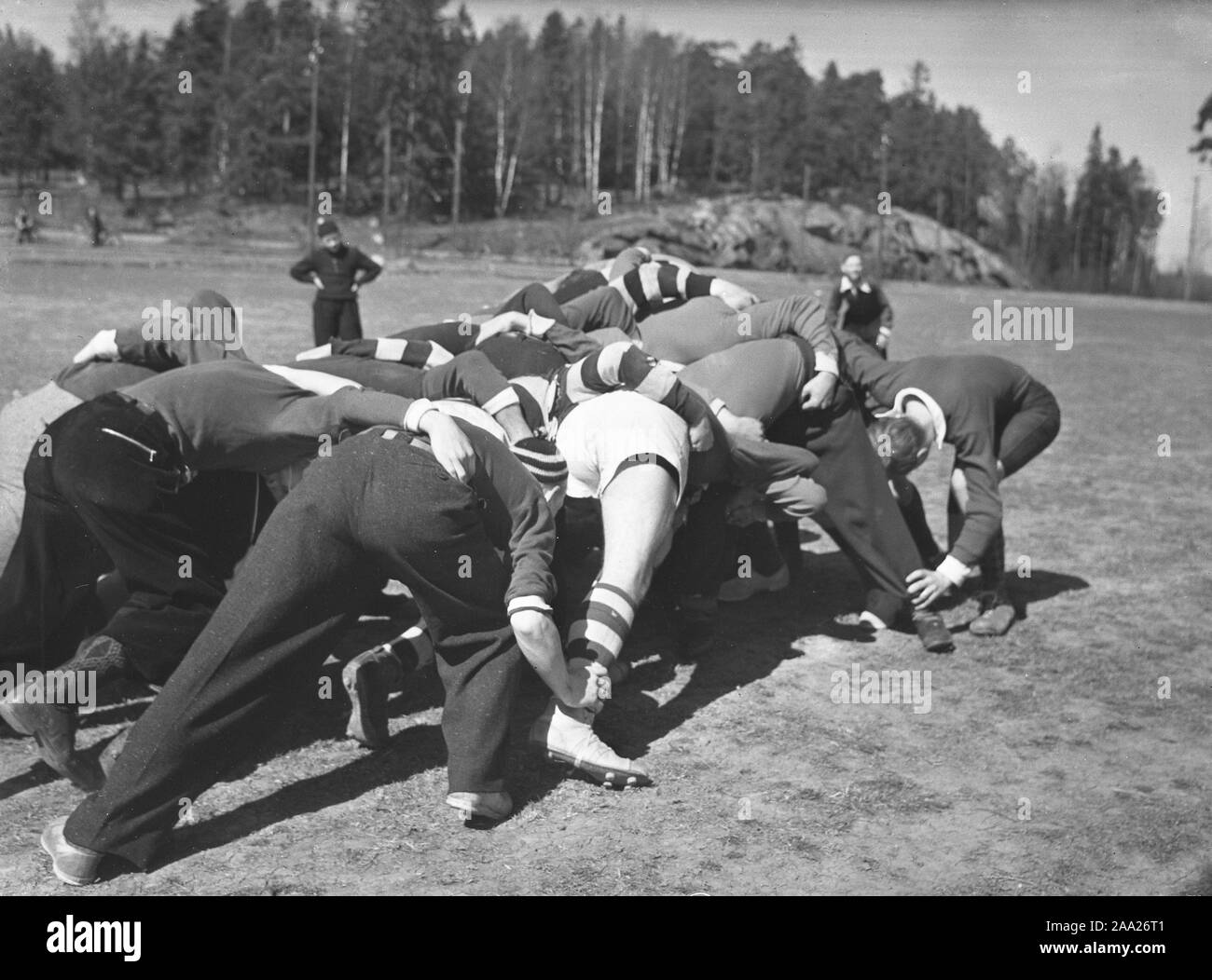 1940s rugby. A group of rugby players are practising on a sunny spring day. The focus is on the ball and all players try their best to get their hands on it. Sweden May 2 1940. Kristoffersson ref 128-12 Stock Photo