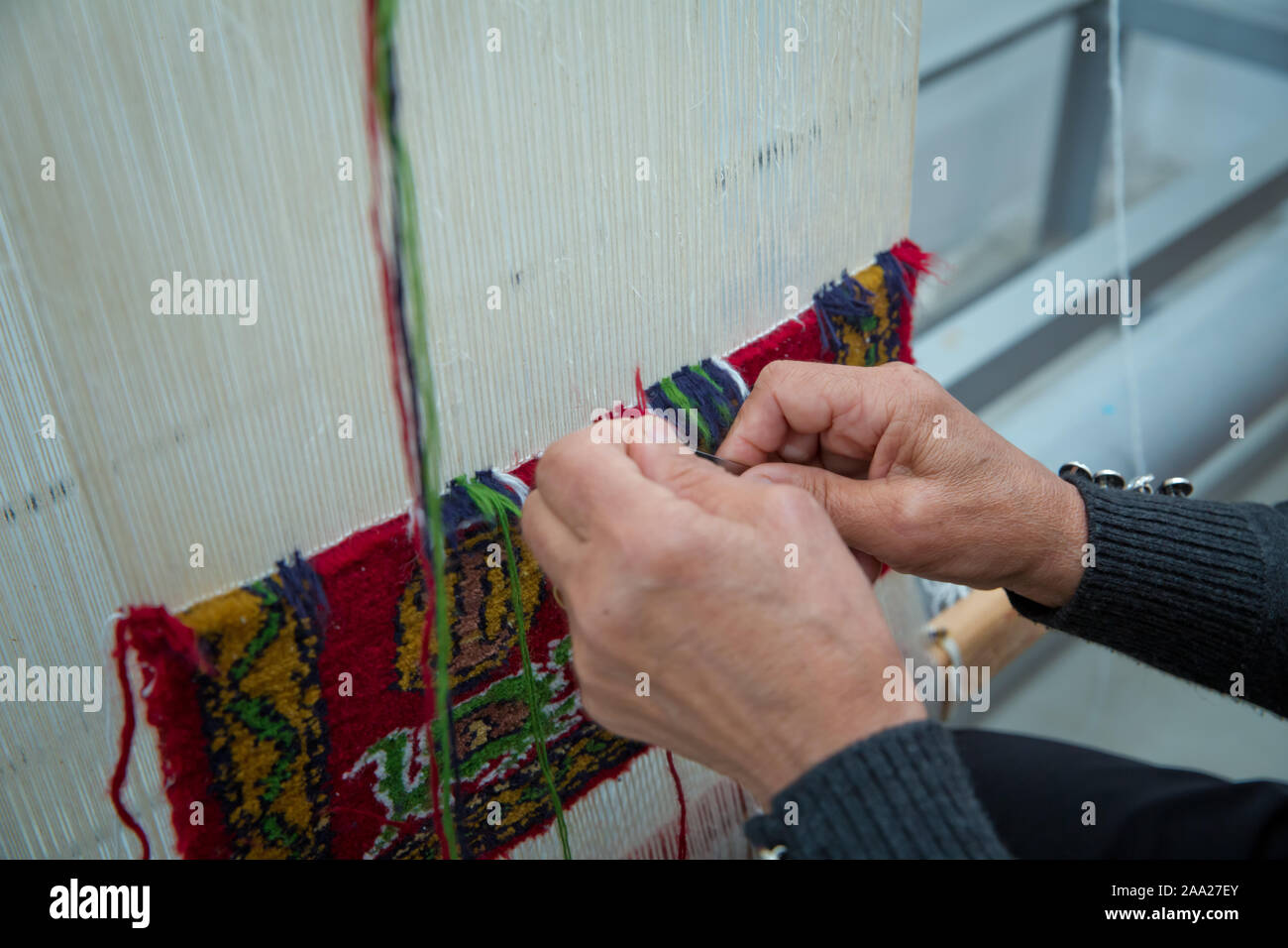 weaving and manufacturing of handmade carpets closeup. women's hands weave a carpet . Woman