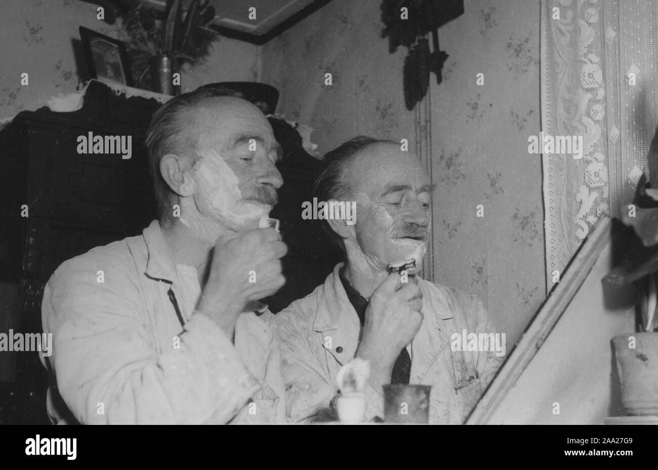 Identical twins. The brothers Erik and Otto Nilsson from Malmö. They both work as painters and are doing their morning shave before going to work. Sweden 1950s Stock Photo