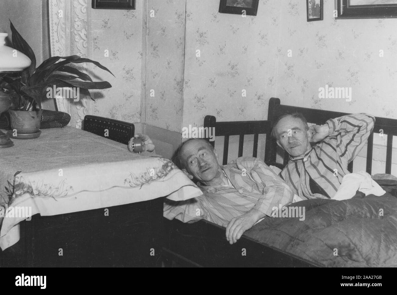 Identical twins. The brothers Erik and Otto Nilsson from Malmö. They both work as painters and is woken up by the alarm clock. Sweden 1950s Stock Photo