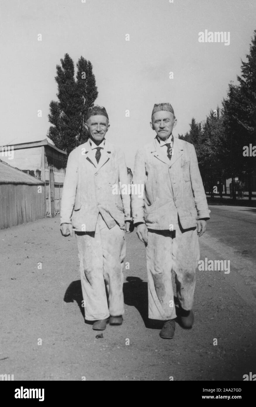 Identical twins. The brothers Erik and Otto Nilsson from Malmö walking down the street. Dressed the same. They both work as painters. Sweden 1950s Stock Photo